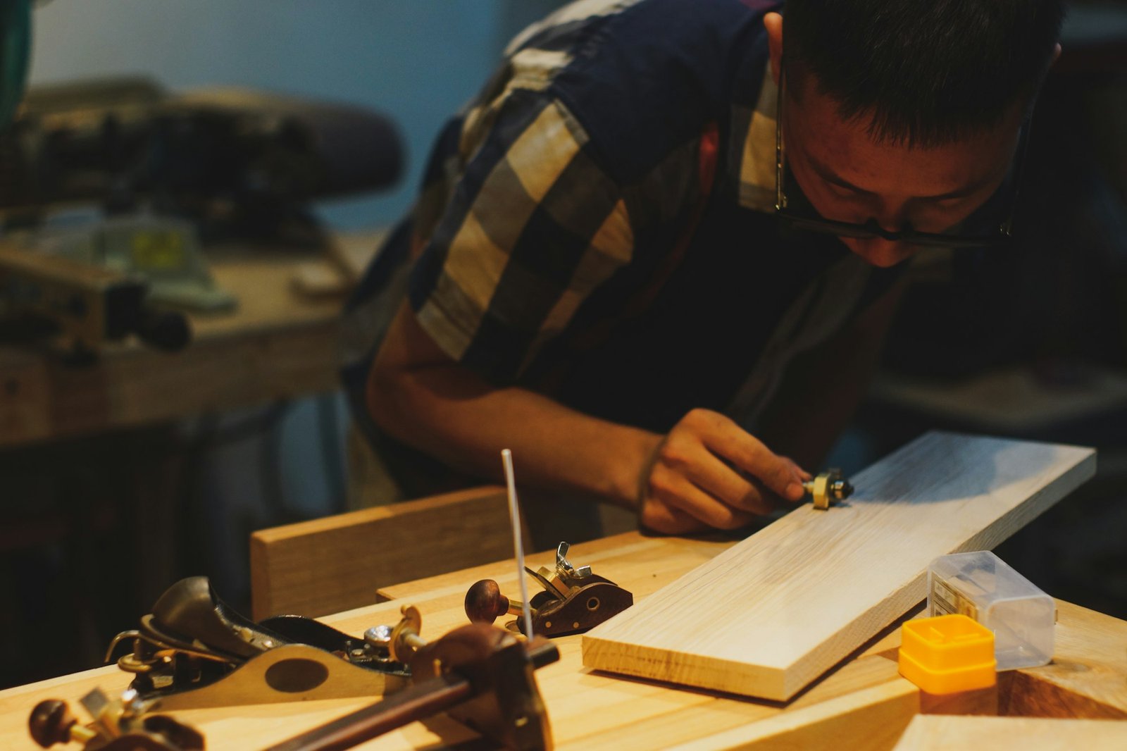 Carpenter shaping wood by hand in a workshop